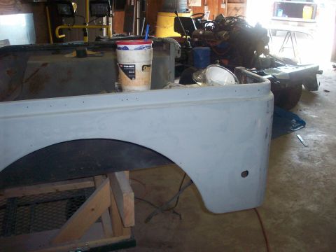 1978 Jeep CJ5 - A Jeep CJ-5 body panel is prepped for paint in a workshop setting, with tools and parts in the background.