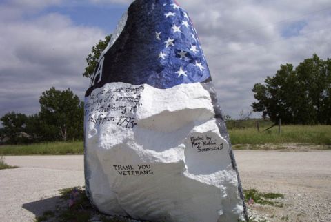1981 Ford Bronco - A large rock painted with an American flag and patriotic messages, including 'Thank You Veterans'.