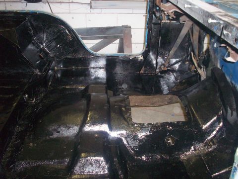 1978 Jeep CJ5 - The interior floor of a vehicle has been coated with black protective material.