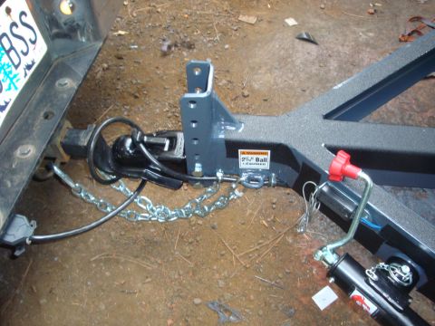 1988 Ford F-350 - Close-up of a trailer hitch and coupler assembly, showing the connection to a vehicle's receiver and safety chains.