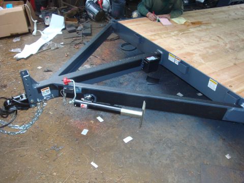 1988 Ford F-350 - Close-up of a trailer's tongue assembly, showing the jack mechanism and safety chains.