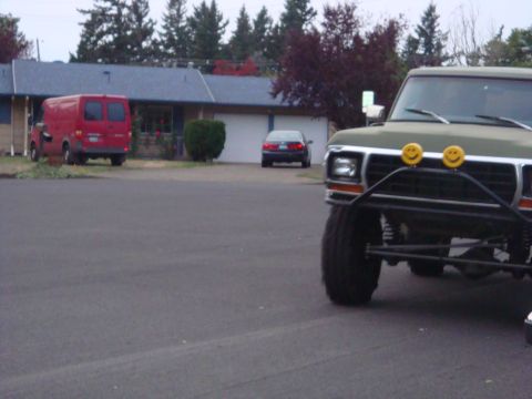 1988 Ford F-350 - A modified green pickup truck is parked in a driveway, with a red van and a sedan visible in the background.