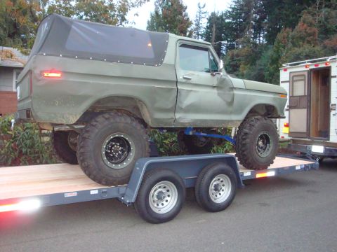 1988 Ford F-350 - Lifted Ford Bronco on a trailer, likely being transported. Model year appears to be from the late 1970s.