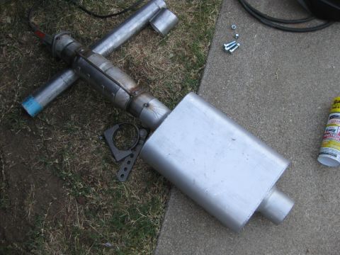 1995 Ford Bronco - Custom exhaust system part laid out on the ground with tools and hardware nearby.