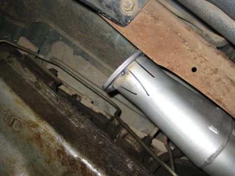 1995 Ford Bronco - Close-up view of an exhaust pipe connection under a vehicle, showing weld marks and cut lines.