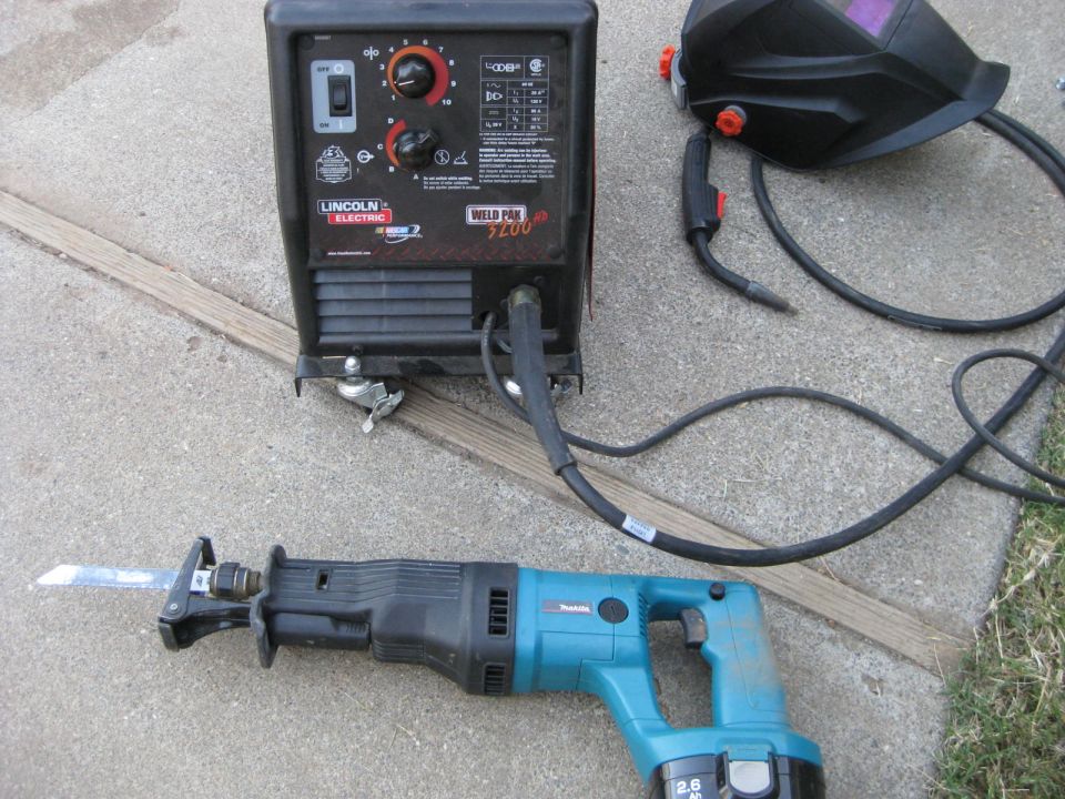 Welding equipment including a Lincoln Electric welder, Makita saw, and helmet