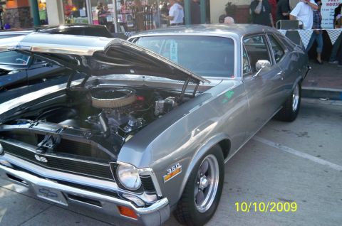 1985 Ford Bronco - A gray 1970 Chevrolet Nova SS is displayed with its hood open, revealing the engine compartment.