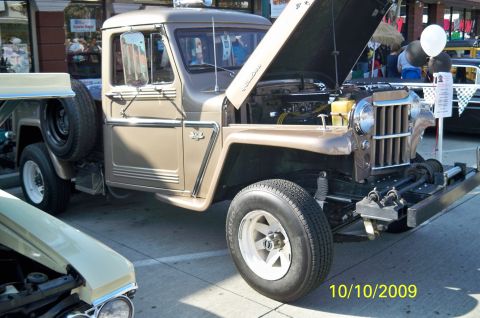 1985 Ford Bronco - A brown pickup truck is displayed with its hood open, revealing the engine and a winch mounted on the front bumper.