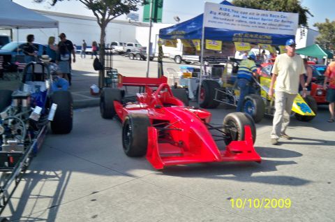 1985 Ford Bronco - Two race cars are displayed outdoors, with a banner and tents in the background. The date 10/10/2009 is visible.