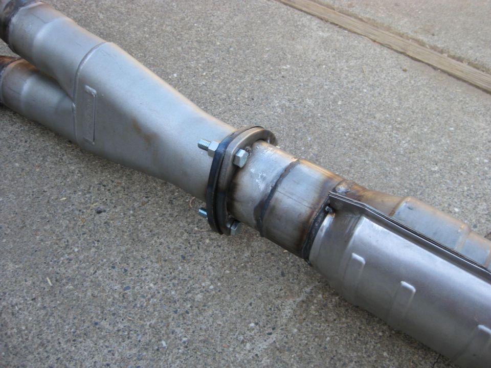 Exhaust y-pipe with a flange connection, resting on concrete