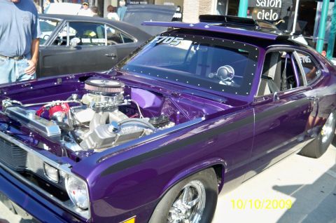 1985 Ford Bronco - Customized purple muscle car with a powerful engine on display, seen at an outdoor event.