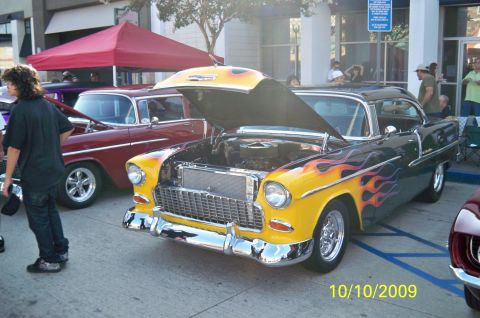 1985 Ford Bronco - A classic 1955 Chevrolet Bel Air with custom paint is displayed at an outdoor event.
