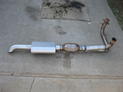 1995 Ford Bronco - Exhaust system a muffler, catalytic converter, and Y-pipe assembly, laid out on a concrete surface.