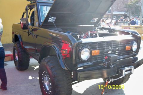 1985 Ford Bronco - This black Ford Bronco, likely from the late 1970s, has its hood open to reveal the engine and is equipped with off-road tires and a winch.