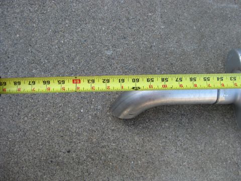 1995 Ford Bronco - A close-up shows an exhaust pipe being measured with a tape measure, indicating its length.