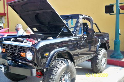 1985 Ford Bronco - Modified black Ford Bronco from the early Bronco generation, hood open to display the engine bay.