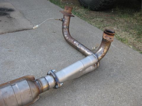 1995 Ford Bronco - Custom exhaust y-pipe assembly with catalytic converter and oxygen sensor, laid out on a concrete surface.