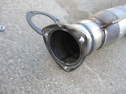 1995 Ford Bronco - Close-up of an exhaust pipe flange and gasket, with a nut visible on the concrete surface.
