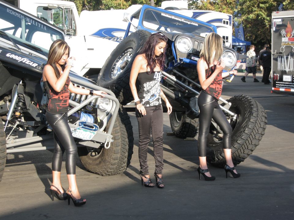 Modified blue Jeep Wrangler with large tires and three women posing