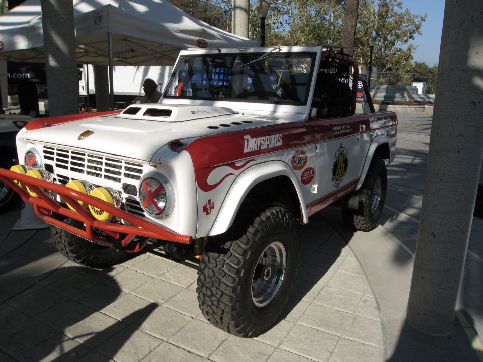 White and red Ford Bronco with off-road tires and a brush guard