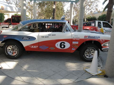 1986 Ford Bronco - This heavily customized sedan, painted in white, red, and blue with racing numbers and sponsor decals, is prepared for off-road competition.
