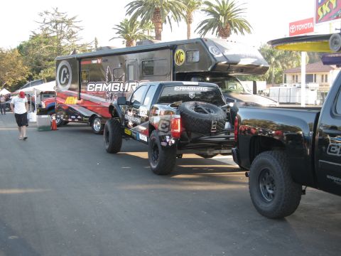 1986 Ford Bronco - Modified pickup truck and RV are parked outdoors, with another truck visible on the right.