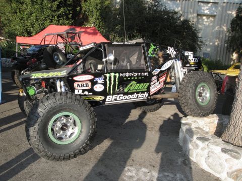1986 Ford Bronco - This heavily modified off-road vehicle features extensive sponsor decals and a roll cage, suggesting it's built for extreme terrain.