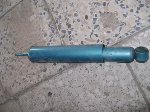 1998 Ford Crown Victoria - A single teal shock absorber is shown, with visible text on its body and a rubber bushing at one end.