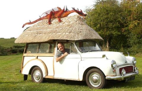 1969 Lincoln Continental - A man poses in a unique Morris Minor Traveller a thatched roof and a dragon decoration.