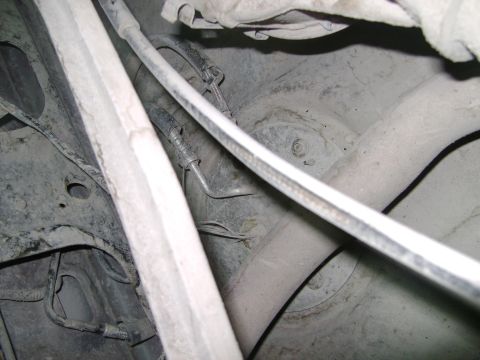 1998 Ford Crown Victoria - Close-up view of the underside of a vehicle, focusing on suspension and exhaust systems.
