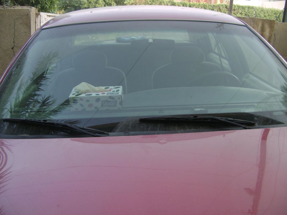 Pink car interior with tissue box on dashboard and windshield wipers