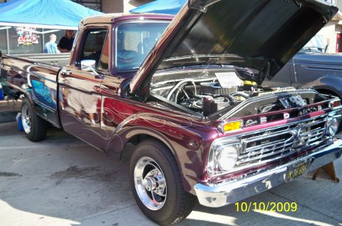 1985 Ford Bronco - Burgundy 1967 Ford pickup truck with custom flames and open hood, parked outdoors.