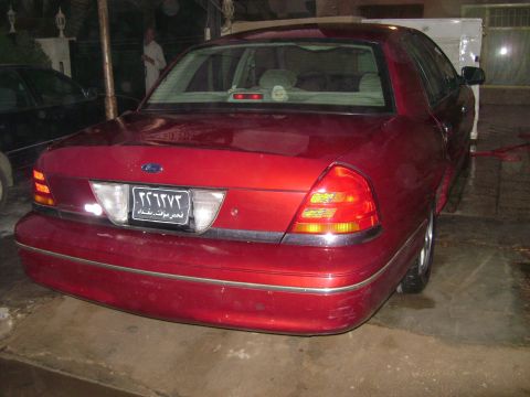 1998 Ford Crown Victoria - Rear view of a red 1998 Ford Crown Victoria sedan with an Arabic license plate.