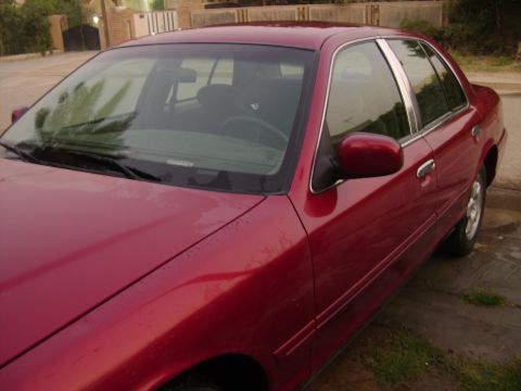 1998 Ford Crown Victoria - The 1998 Ford Crown Victoria is shown from the front passenger side, with a wet exterior.