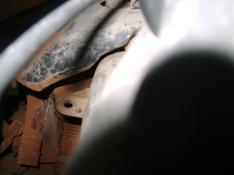 1998 Ford Crown Victoria - Close-up view of a rusted metal bracket and pipe, likely from a vehicle's engine compartment.