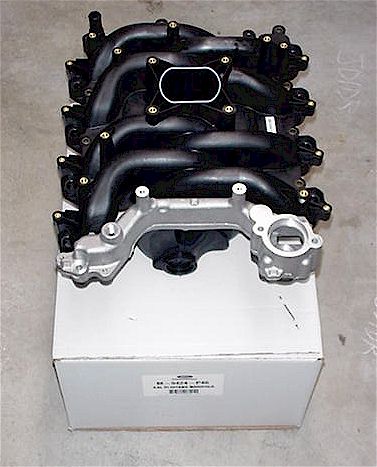 1998 Ford Crown Victoria - A black plastic intake manifold is shown resting on a white cardboard box.