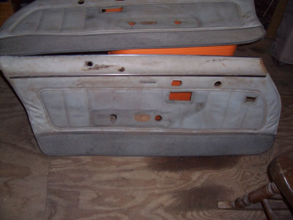 two old car door panels stacked on a wooden floor