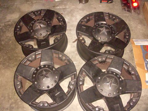 1993 Ford Bronco - A set of four aftermarket wheels are displayed on a concrete surface, likely for sale or installation.