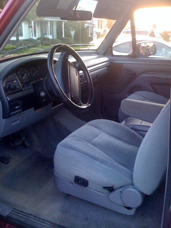 Gray cloth interior of a 1990s Ford truck showing dash and seats