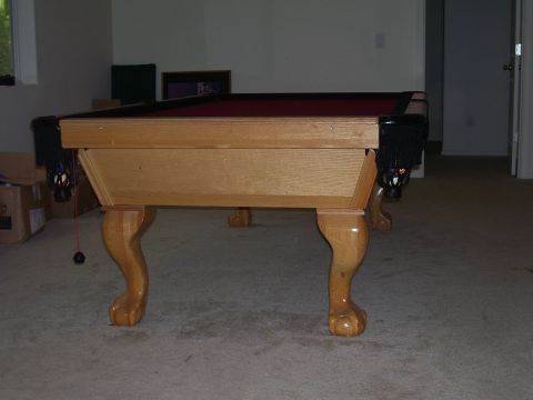 1991 Ford Bronco - A wooden pool table with ornate clawed feet and red felt is shown in a room.