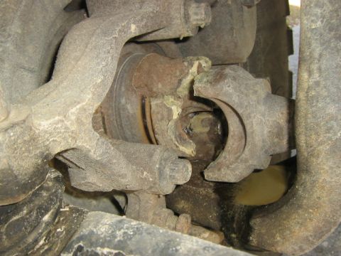 1998 Dodge 1500 - Close-up view of a damaged CV joint, showing a torn boot and significant grease leakage.