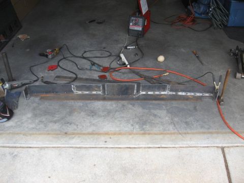 1995 Ford F-150 - A custom metal bumper part is shown with welding equipment and tools in a garage setting.