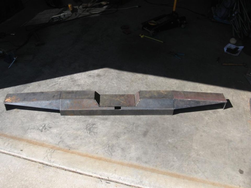 Custom fabricated steel bumper, unfinished, lying on concrete floor