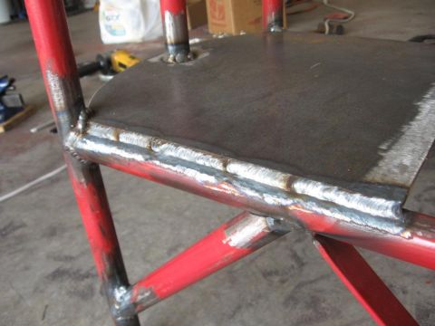 1995 Ford F-150 - Close-up view of a red metal frame with numerous welds, likely part of a welding cart.