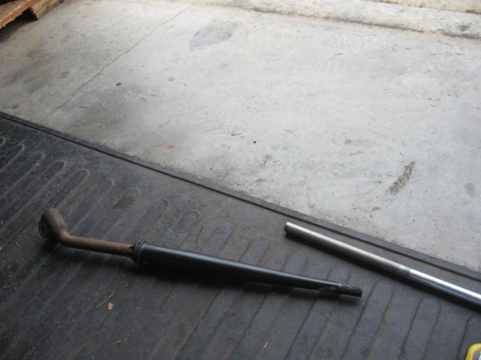 Drive shaft with a bent end and a separate metal tube on a ribbed black surface