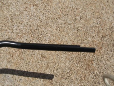 1995 Ford F-150 - Close-up of a black metal shifter lever, likely for a manual transmission, resting on a concrete surface.