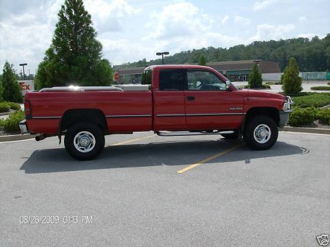 1989 Ford Bronco - This red Dodge Ram 2500 pickup truck is shown from the side, parked in a lot.
