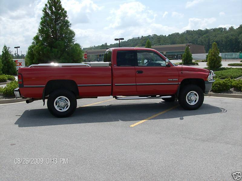 Red Dodge Ram 2500 pickup truck, side view. Has a toolbox in the bed
