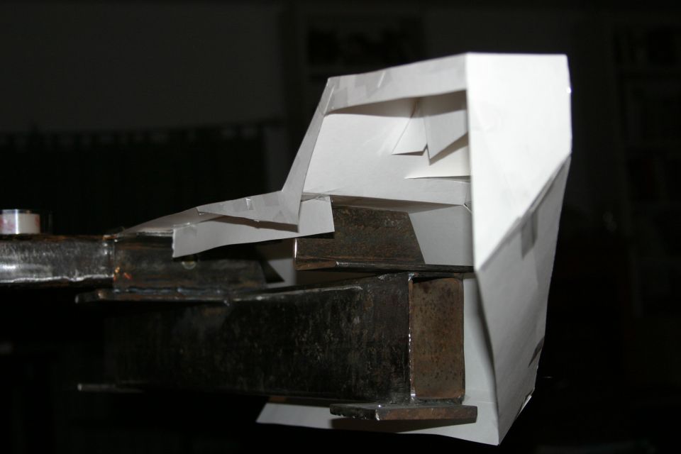 Metal frame with a white paper model attached, viewed from the side