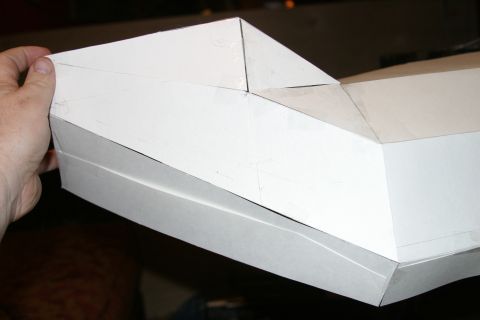 1987 Suzuki Samurai - A hand holds a white cardboard model, possibly a prototype or scale model, showing angular body lines.